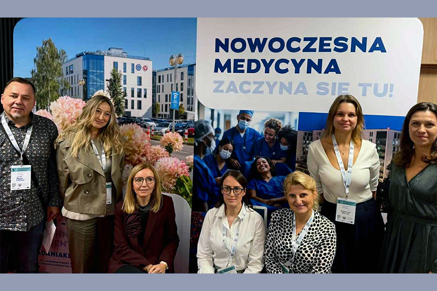 A group of participants from the Medical University of Warsaw posing for a photo in front of a banner reading “Modern Medicine.”