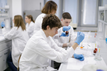 Młodzi ludzie w fartuchach medycznych przeprowadzają badania w laboratorium