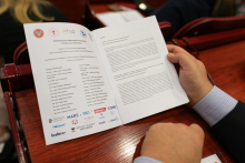 Ręce trzymające broszurę z programem konferencji