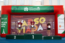 Trzy młode kobiety ubrane na sportowo stoją na podium.