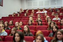 Młodzi ludzie różnych narodowości siedzą w auli.