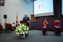 Mężczyzna przemawia przy mównicy podczas uroczystości dyplomatorium