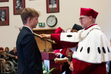 Rektor pasuje młodego mężczyznę na studenta. 