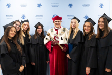 Grupa osób pozująca do zdjęcia. W środku rektor, po bokach członkinie samorządu studentów.