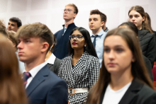 Grupa młodych osób ubranych formalnie. To studenci, którzy ślubują przyrzeczenie studenckie.