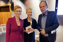 Trzy elegancko ubrane osoby: dwie kobiety i jeden mężczyzna pozują do zdjęcia. Uśmiechają się.