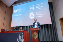 Klaudiusz Komor, przy mównicy z napisem ‘Veritatis Splendor’ i przemawia podczas konferencji. Na ekranie w tle widnieją logotypy organizatorów: SAVE A LIFE, Naczelna Izba Lekarska i Polskie Towarzystwo Lekarskie. 