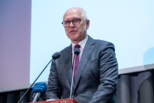 Rektor WUM stoi przy mównicy przemawia podczas konferencji. 