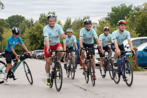 A group of people wearing helmets and sportswear are riding bicycles.