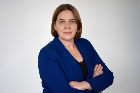 Elegancko ubrana kobieta stoi z założonymi rękami